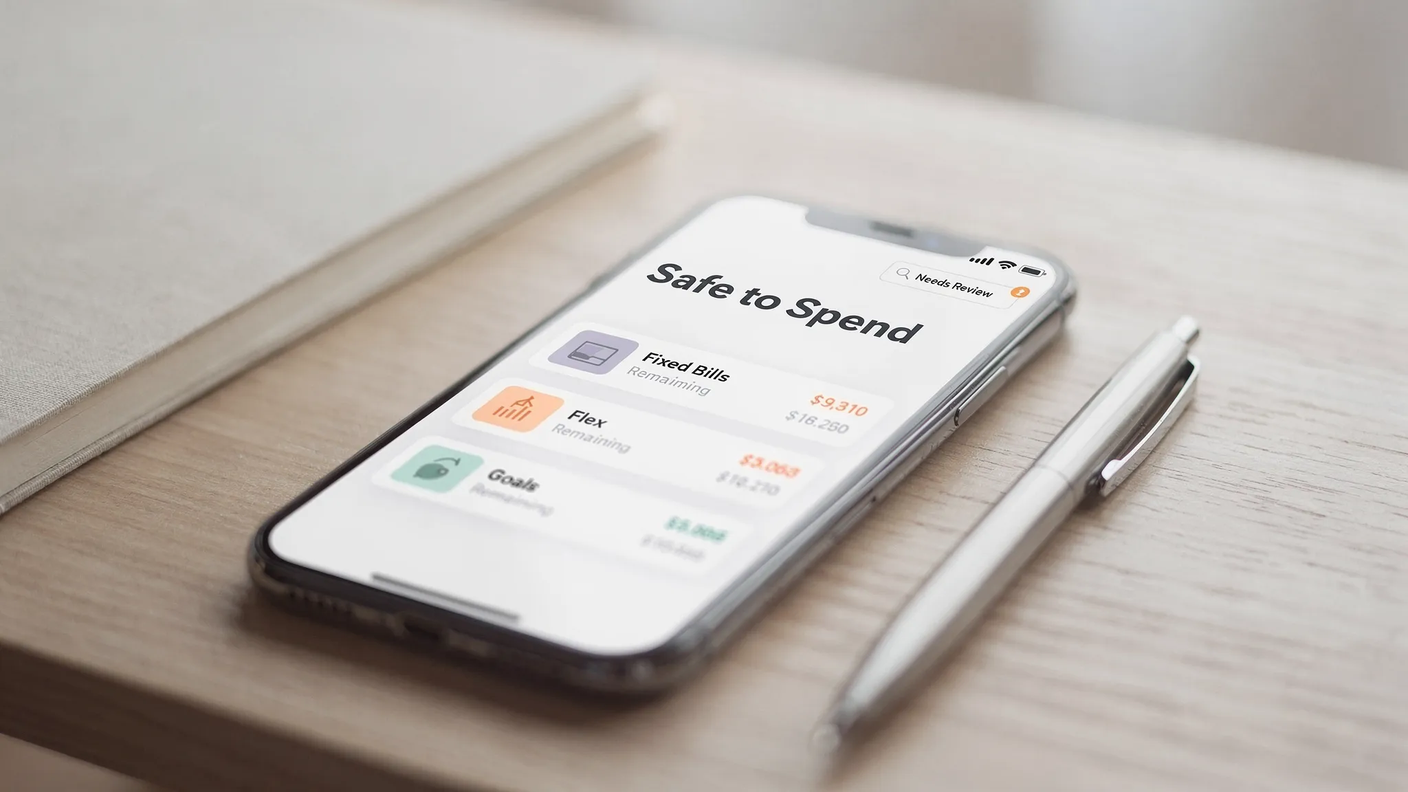 A modern smartphone showing a simple budgeting dashboard with clear category groups (Fixed Bills, Flex, Goals), a safe-to-spend number, and a small âNeeds Reviewâ inbox indicator. No brand logos, clean minimal interface.