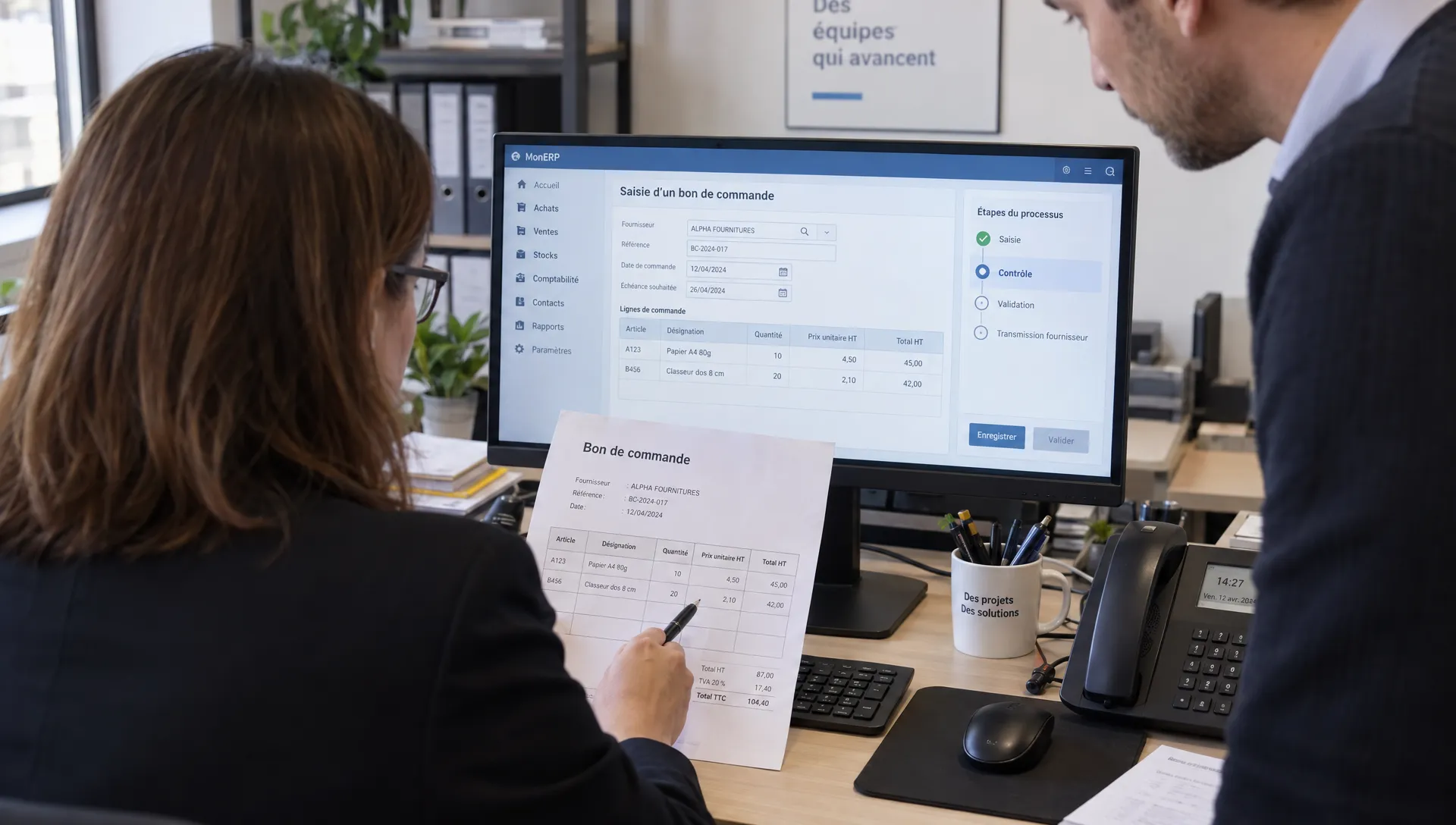 Une responsable et un gestionnaire vérifient un bon de commande face à une saisie ERP proposée, encore en attente de validation.