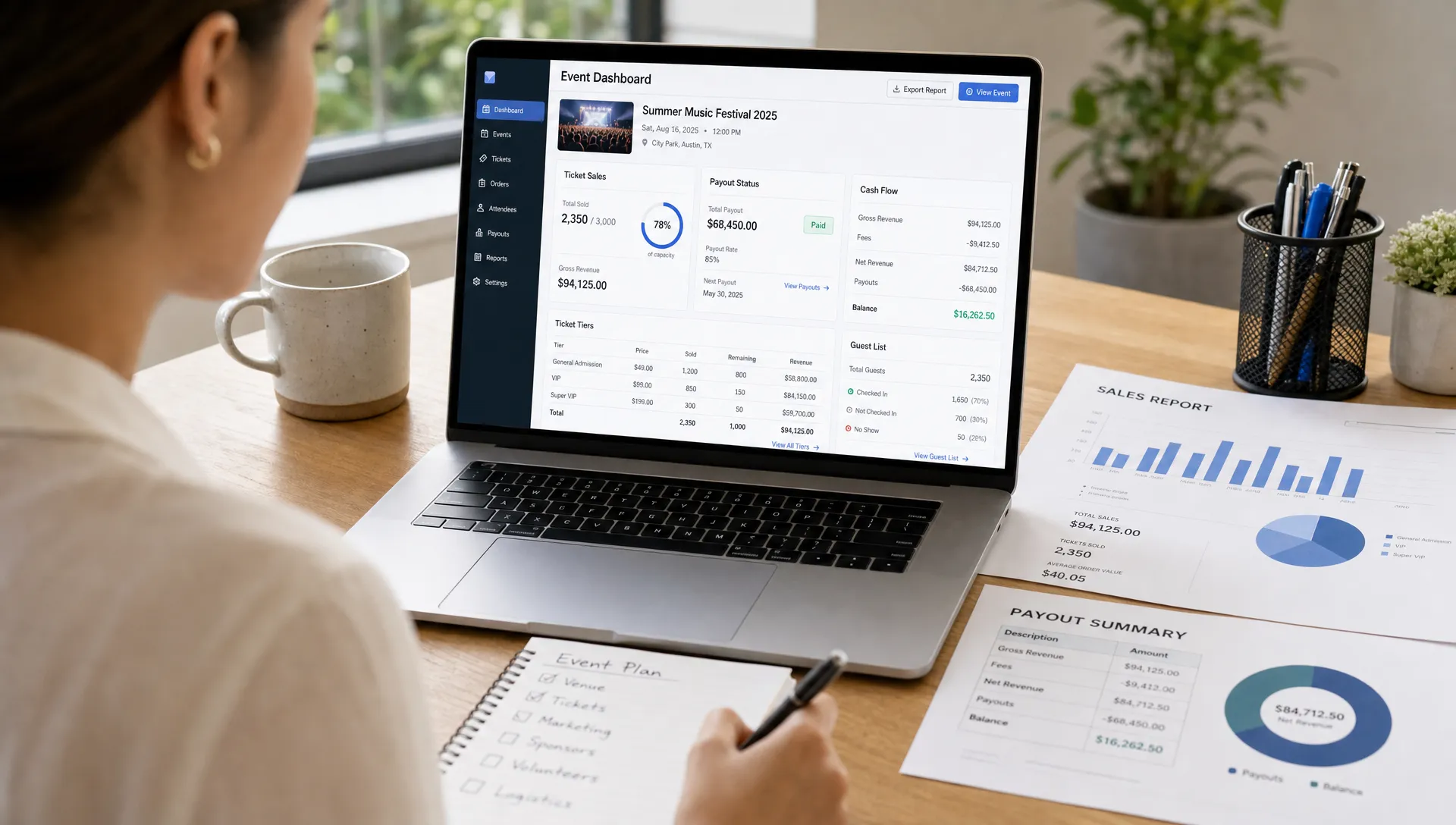 An event organizer reviewing ticket sales, payout status, ticket tiers, and guest list details on a laptop and paper reports in a bright indoor office workspace, with the screens facing the camera and cash flow information clearly organized.