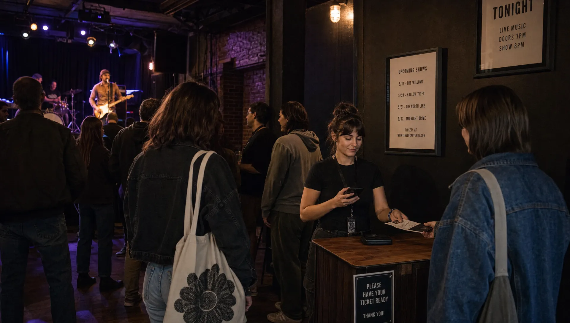 An intimate live music venue shows a small crowd near the stage and a ticket check-in point by the entrance.