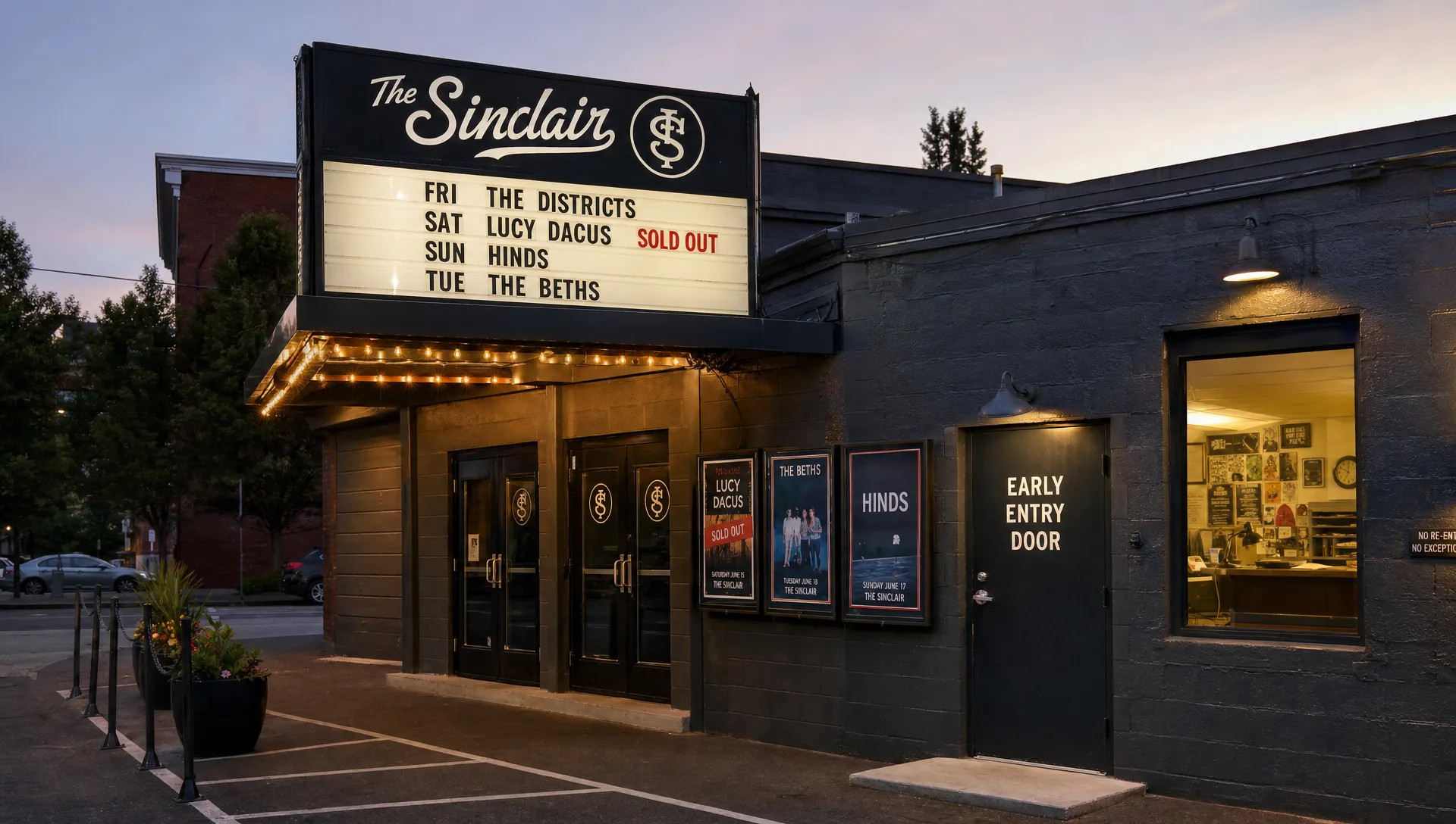 Landscape wide exterior of a small club or performance venue at dusk, with the entrance, marquee, and a few posted show notices visible, plus a side door used for early access and a lit window showing staff activity inside. No people in the foreground. The frame should establish the real place where warm audiences already know the event and are likely to buy quickly.