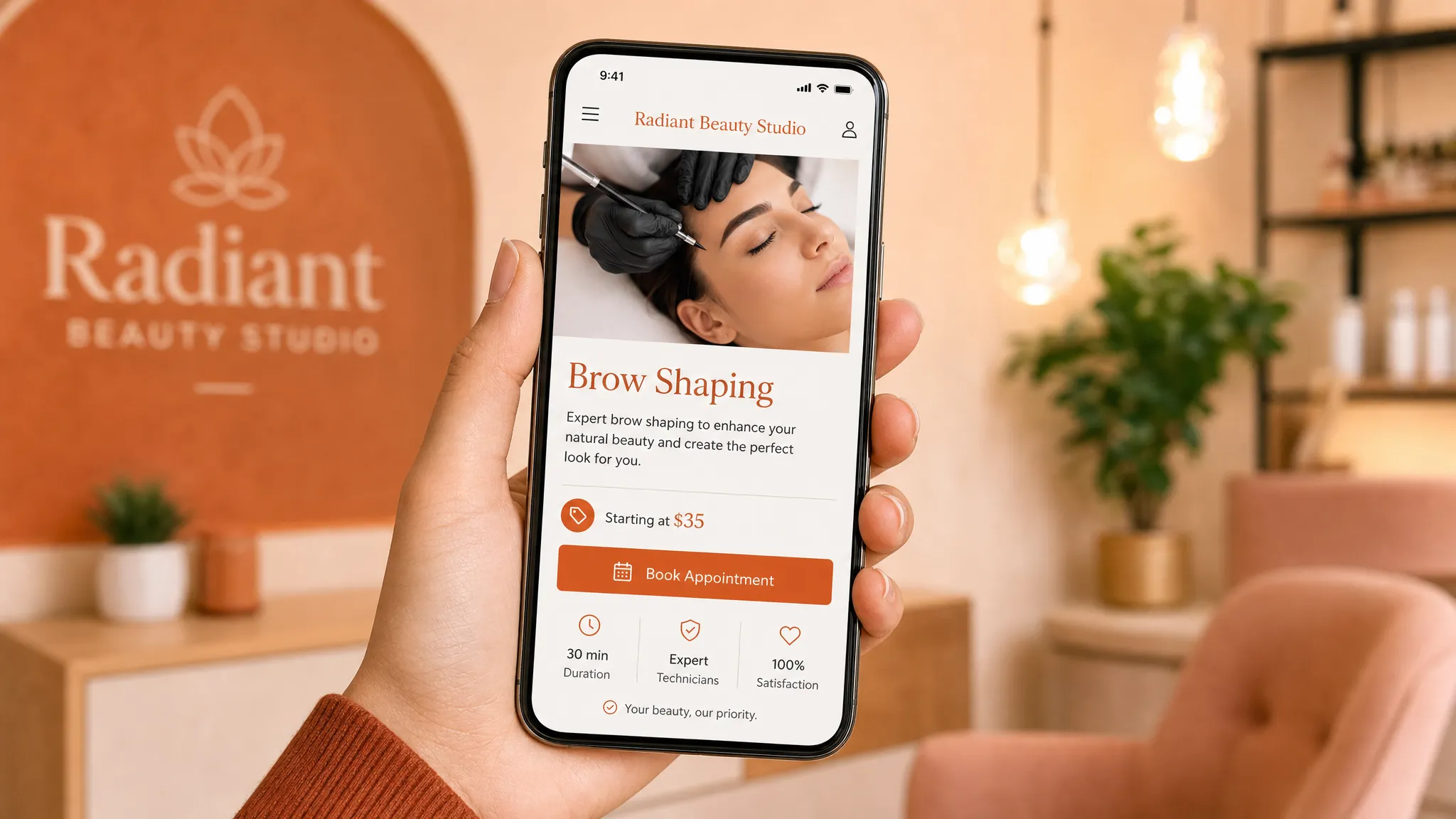 A hand holding a phone with the screen facing forward, showing a clean booking page for a local beauty studio with a service heading, short description, price note, and clear booking button.
