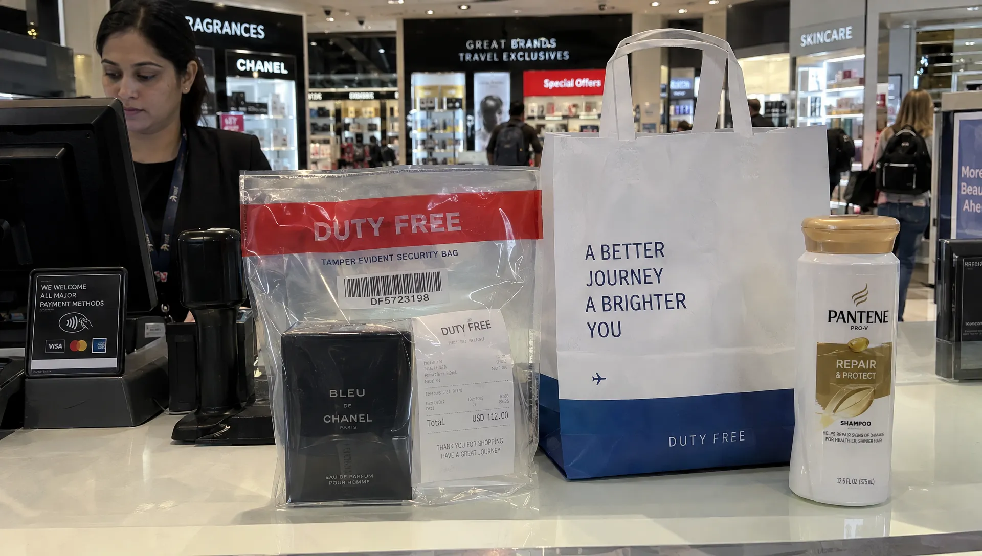 A sealed perfume bag with its receipt sits beside a shopping bag holding full-size shampoo, illustrating travel rules for toiletries.