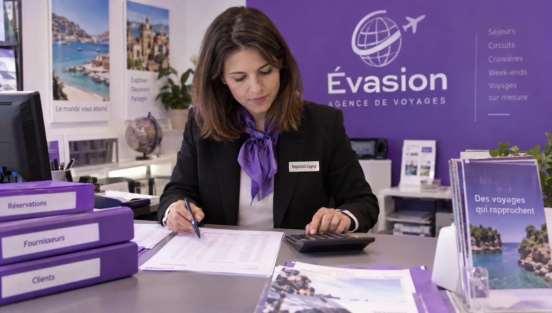Une responsable d’agence de voyages compare au comptoir des montants de paiements fournisseurs et de remboursements clients inscrits sur une feuille, près de dossiers de réservation.
