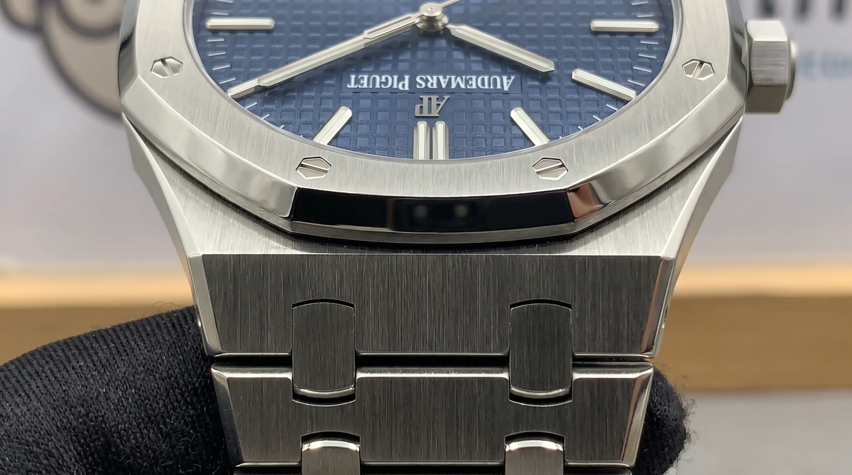 Close-up of a Royal Oak bracelet and octagonal bezel, showing brushed surfaces, polished bevels, aligned screws and a textured dial.