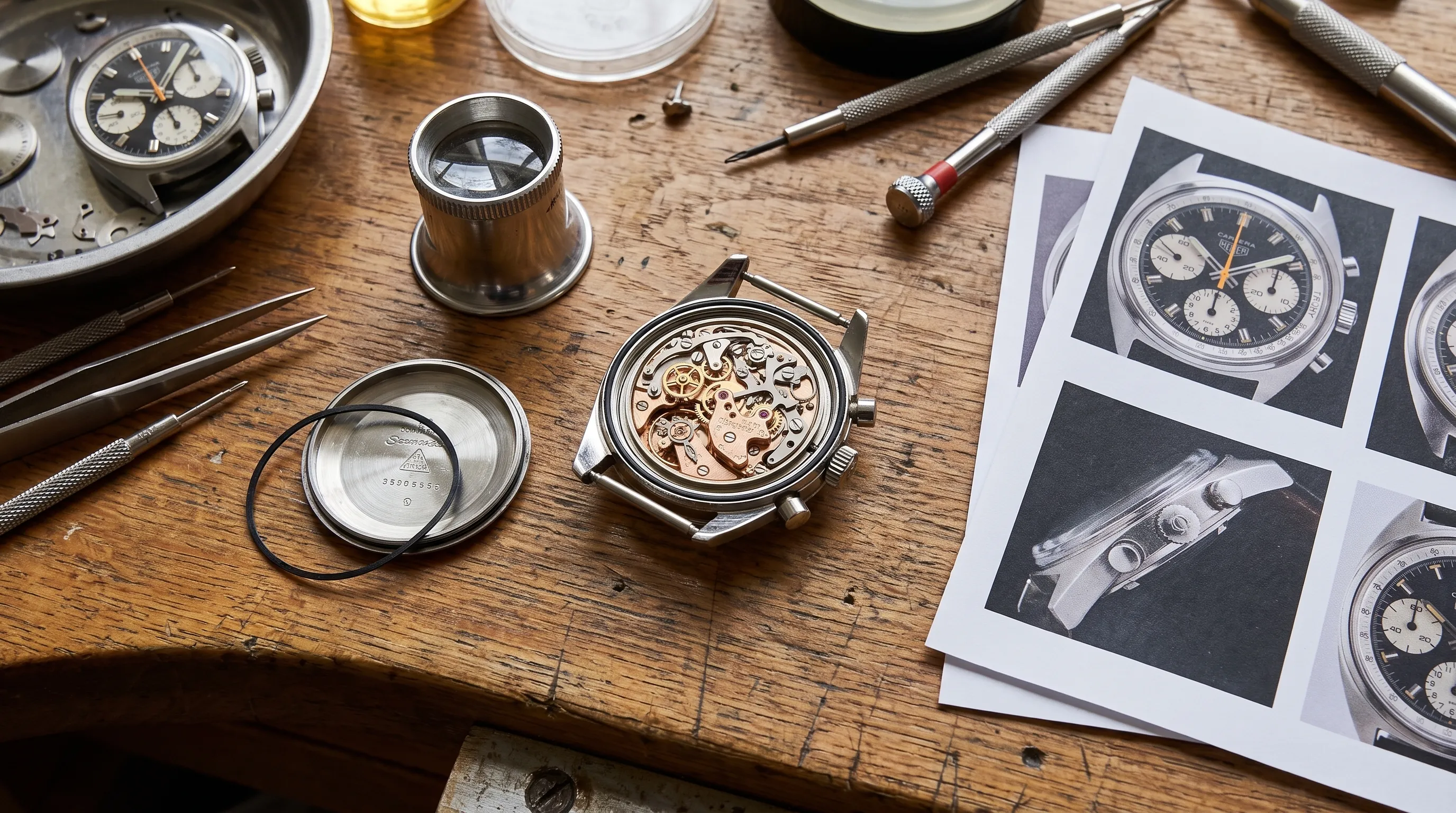 Close-up of a vintage Omega Seamaster on a watchmaker’s bench with its caseback removed, a loupe nearby, and reference photographs beside it.