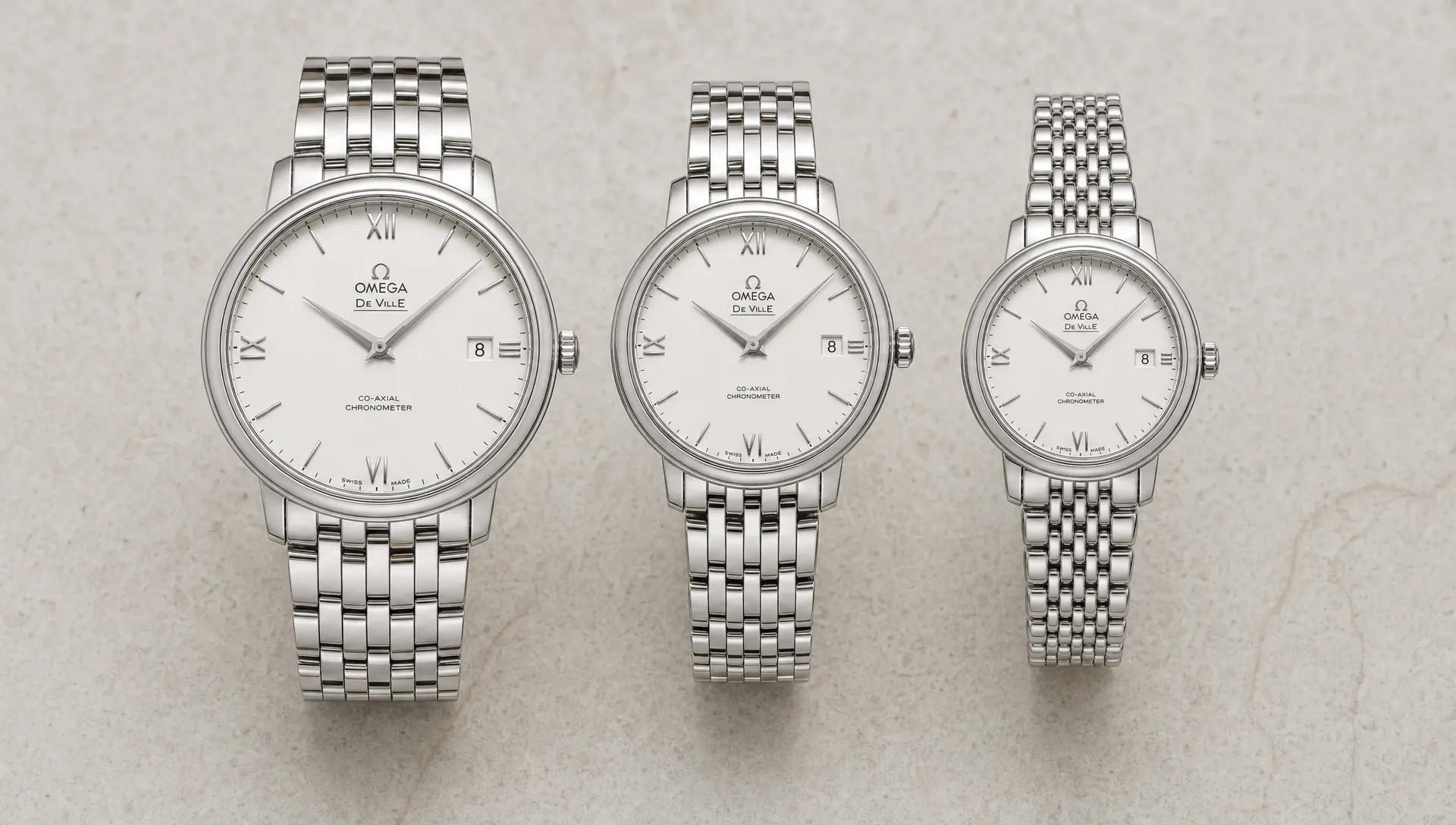Three Omega De Ville Prestige watches arranged side by side, showing different dial sizes and bracelet styles for comparison.