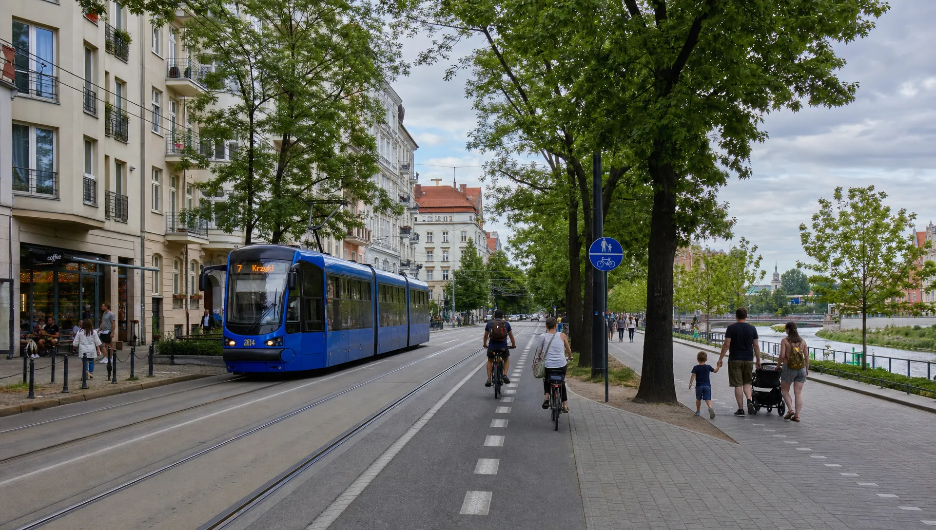 A calm residential street in Wrocław with tram tracks, leafy trees, apartment buildings, cyclists, and families walking near a riverside park, showing everyday life rather than tourism.