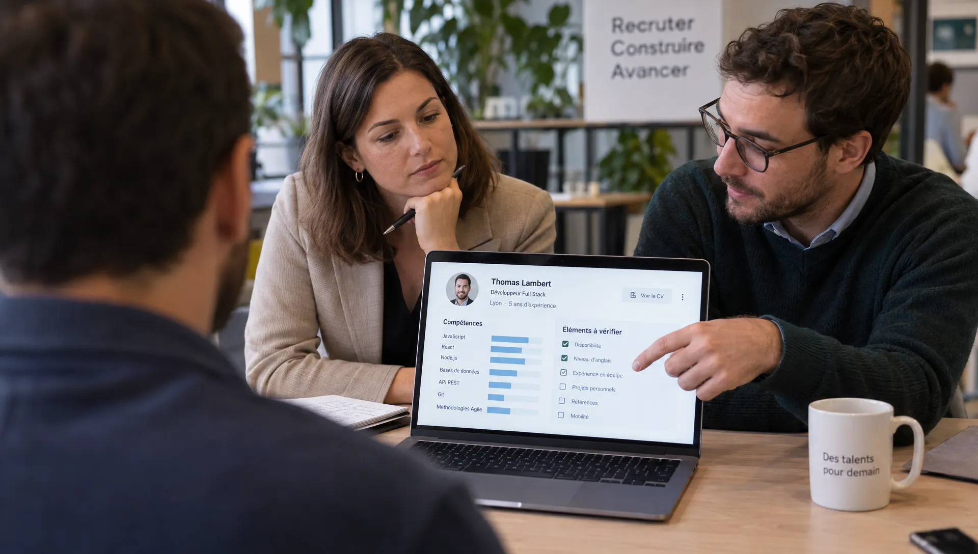 Deux recruteurs confrontent leurs observations devant une fiche de compétences pour vérifier une recommandation de présélection.