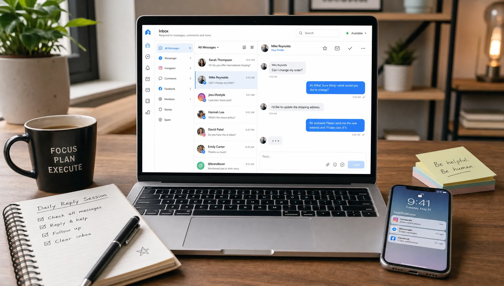A focused morning workspace with a notebook, coffee, and a laptop showing a social media inbox from a front-facing angle with the screen oriented correctly. A phone rests nearby with notifications visible, and the setup suggests a short daily reply session.