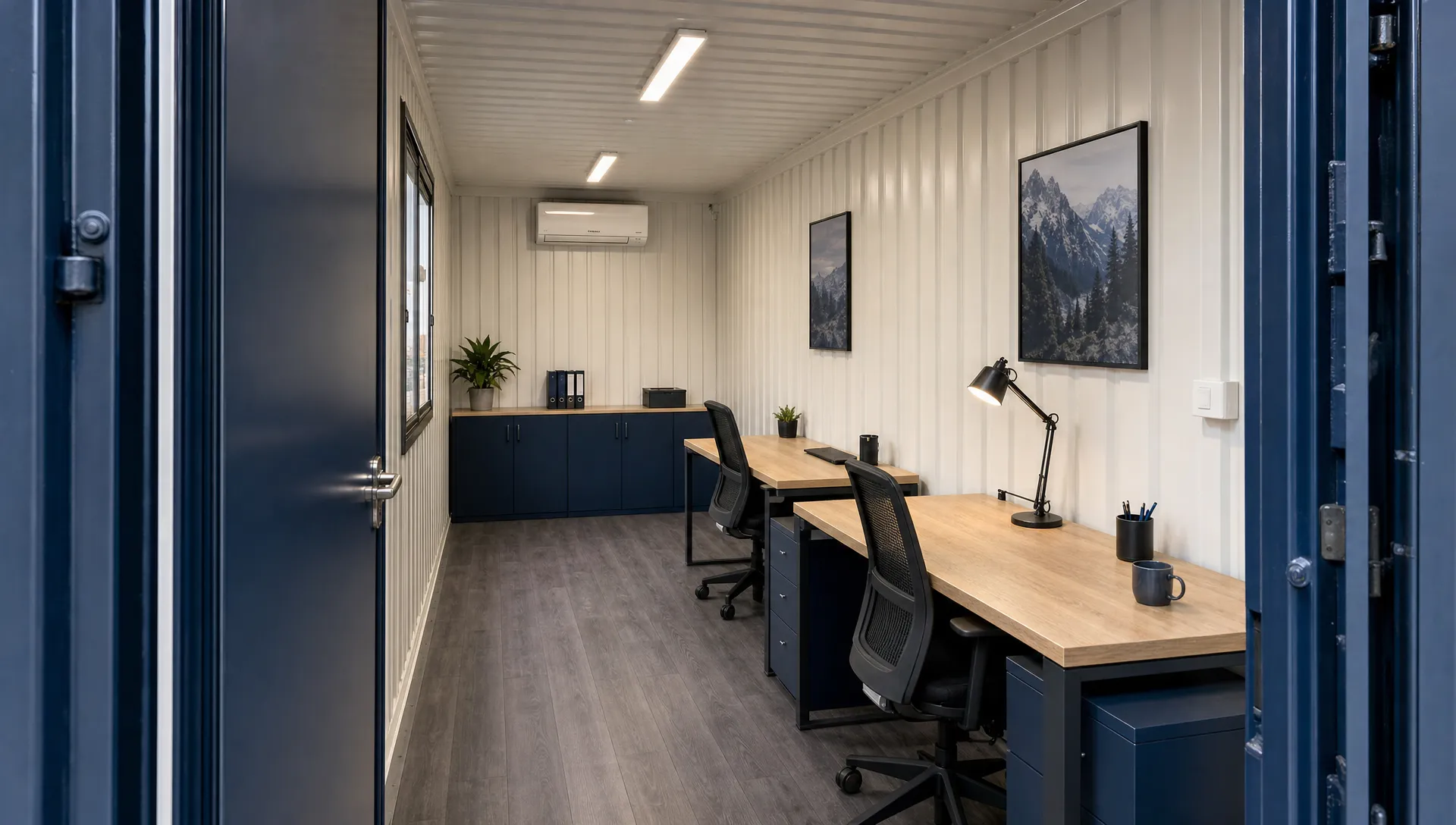 Interior of a 20ft shipping container office with two desks along one wall, shallow cabinets at the back and a clear path from the entrance.