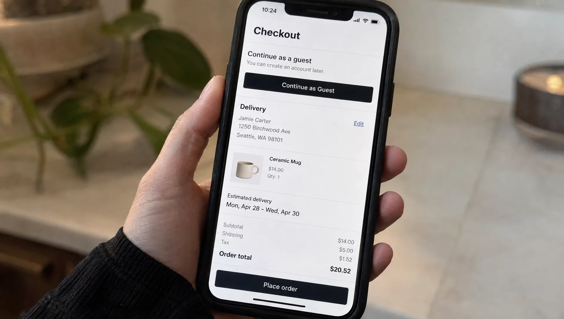 A phone on a retail checkout page shows guest checkout, a delivery estimate, retained address details, and a clear order total.
