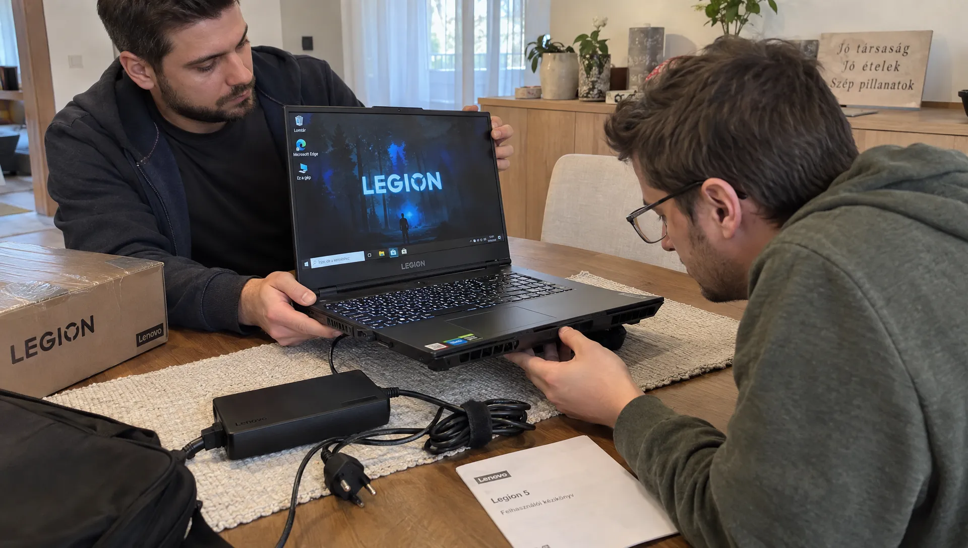Vevő vizsgálja egy Lenovo Legion 5 kijelzőjét és szellőzőnyílásait, miközben az eladó mellette tartja a gépet.