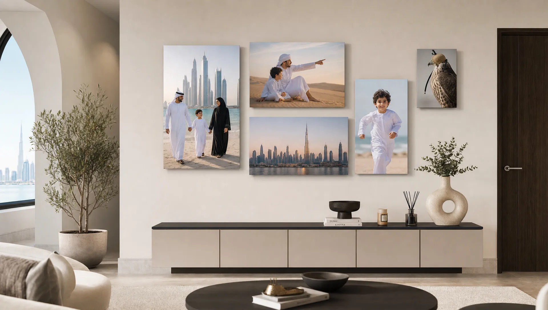 A UAE living room wall displays several canvas photo prints in different sizes above a console table.