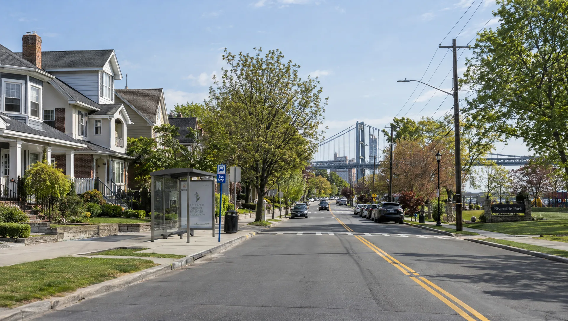 Landscape wide street-level view of a residential neighborhood where a local home search might take place: a row of varied houses, a small park, a bus stop, and a road leading toward a visible bridge. No person dominates the scene; the connected streets and neighborhood landmarks make the search area itself the subject.