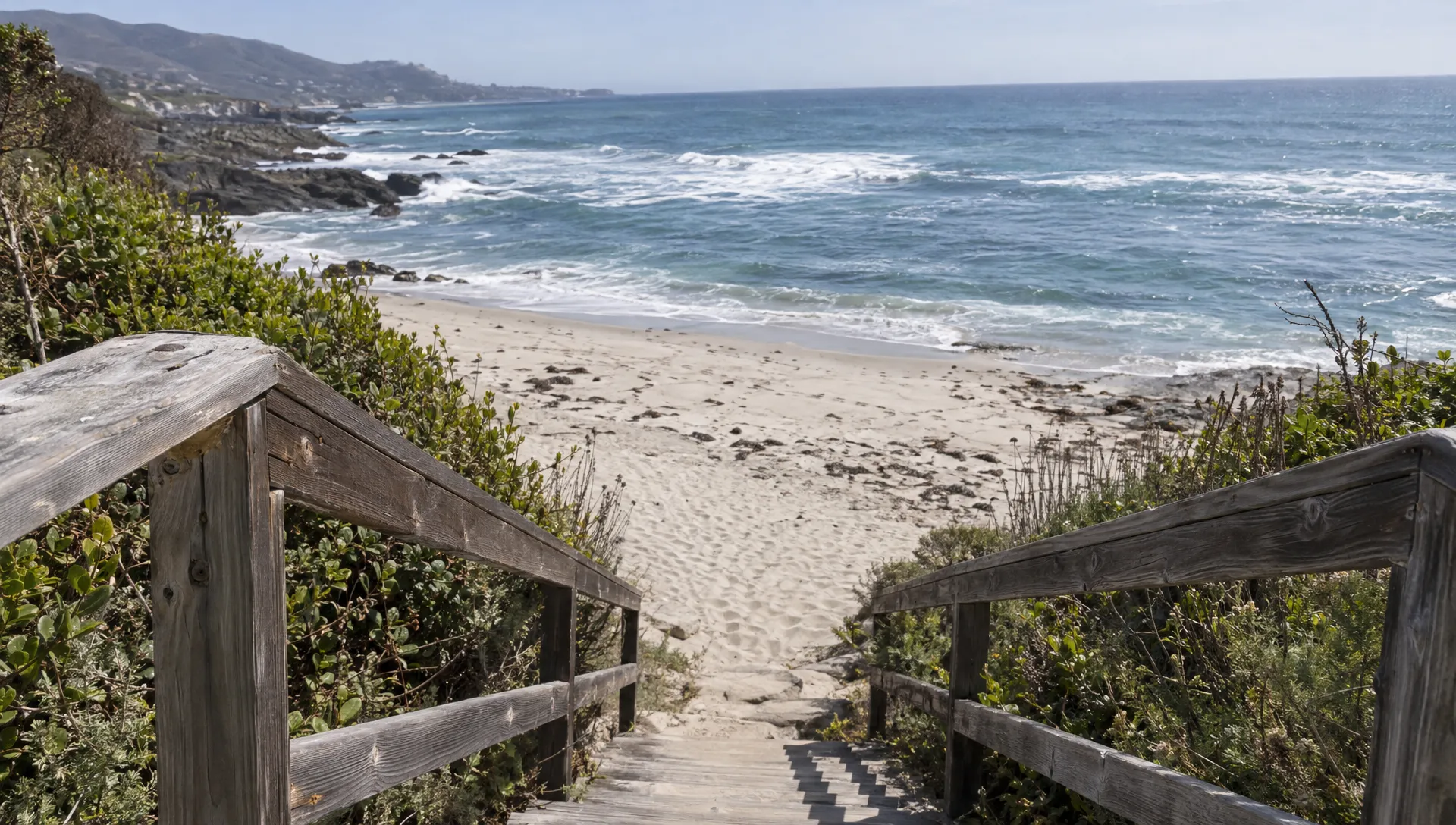 A neighborhood stairway and handrail lead down toward the beach, showing the access route guests should check.