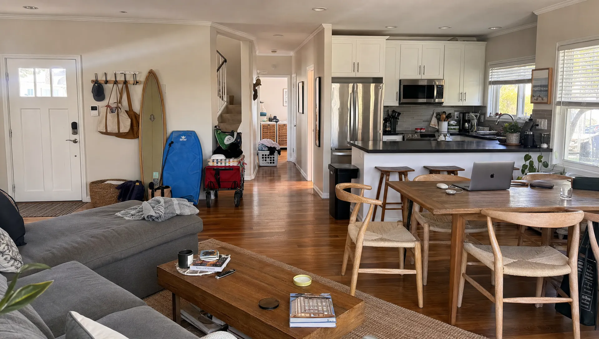 A Manhattan Beach home looks settled for a month-long stay, with beach gear, a laptop, and laundry showing everyday rental use.