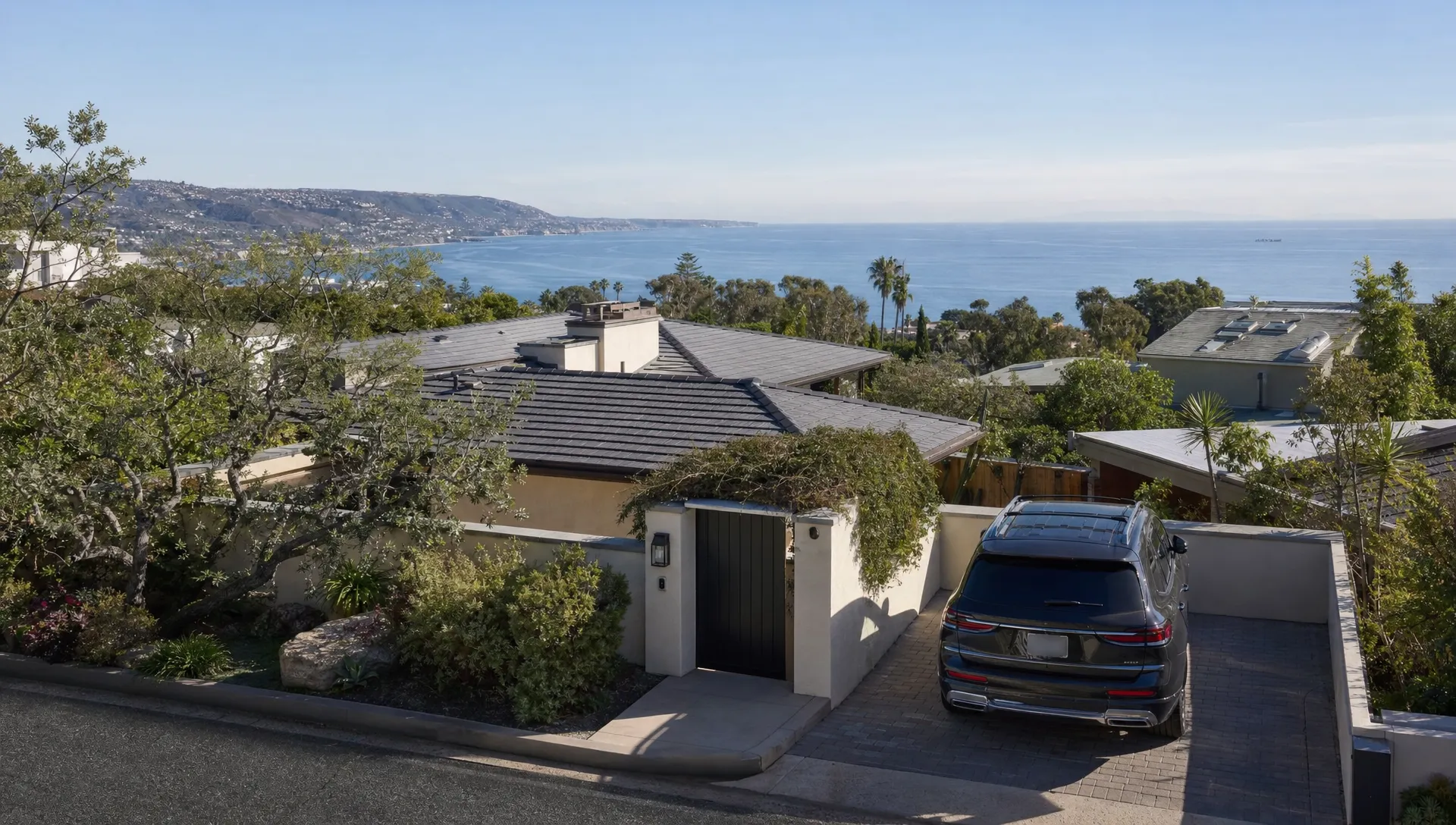 A Laguna Beach hillside home shows a private terrace, reserved parking, and a discreet entry.